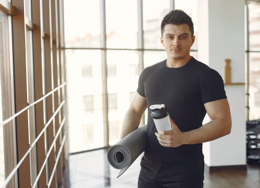 Mężczyzna na siłowni korzystający z białko odżywki, by efektywnie budować masę i wspierać redukcję, osiągając najlepsze wyniki.