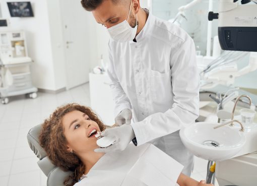 Nowoczesna odbudowa zęba w Krakowie – pacjent podczas dopasowania korony odbudowującej ząb po urazie.