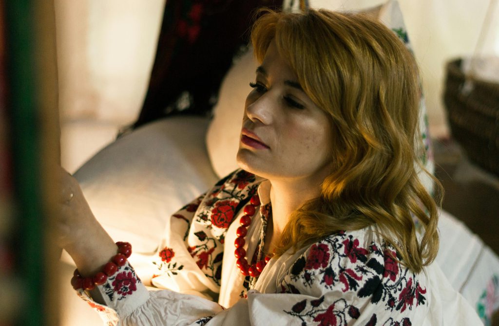 Kobieta szyjąca stroje dla kół gospodyń wiejskich.